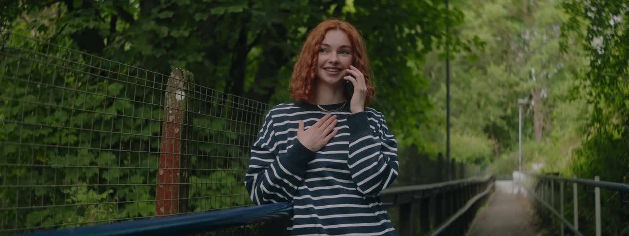 Woman in a natural environment with trees around talking on a call