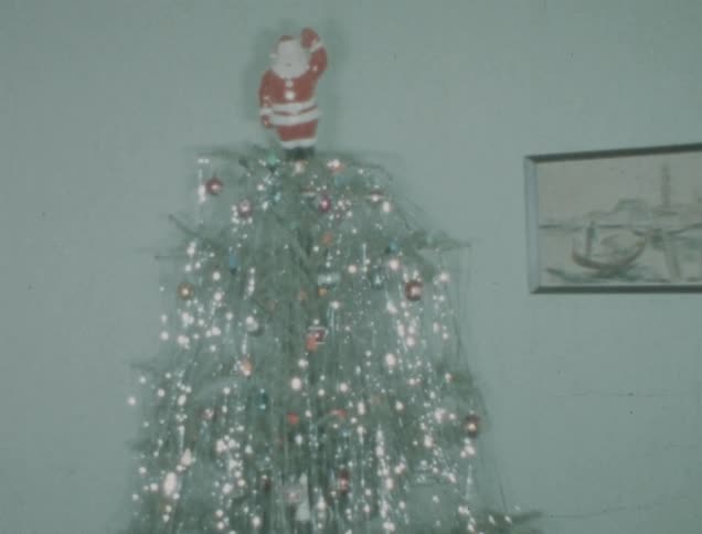 Christmas tree decorated with bright ornaments and a santa claus at the top