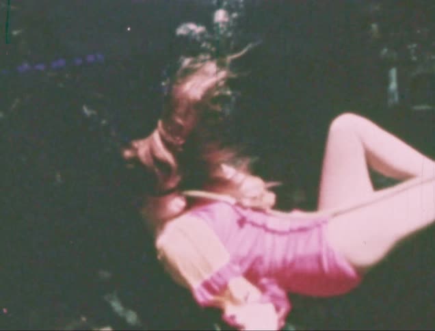 A weeki wachee mermaid performing underwater captured on vintage film