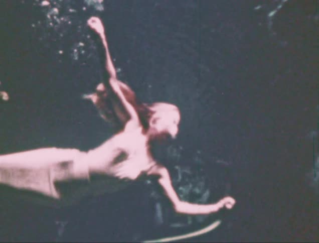 A weeki wachee mermaid performing underwater captured on vintage film