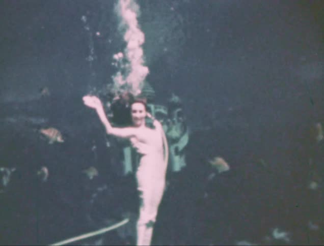 A weeki wachee mermaid performing underwater captured on vintage film