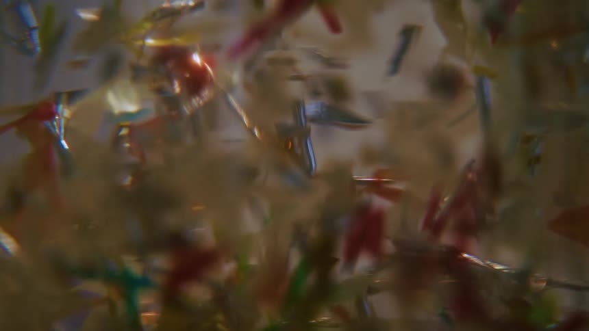 A colorful assortment of blurred figurines floating down a clear thick liquid
