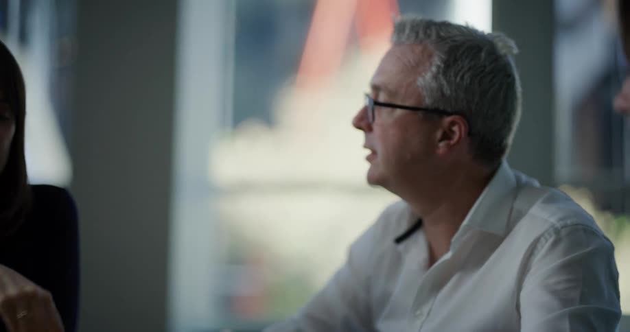 People in an office discussing a project while sitting at a desk
