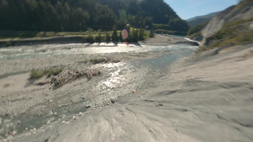 Natural landscape of a river surrounded by mountains and vegetation fpv drone view