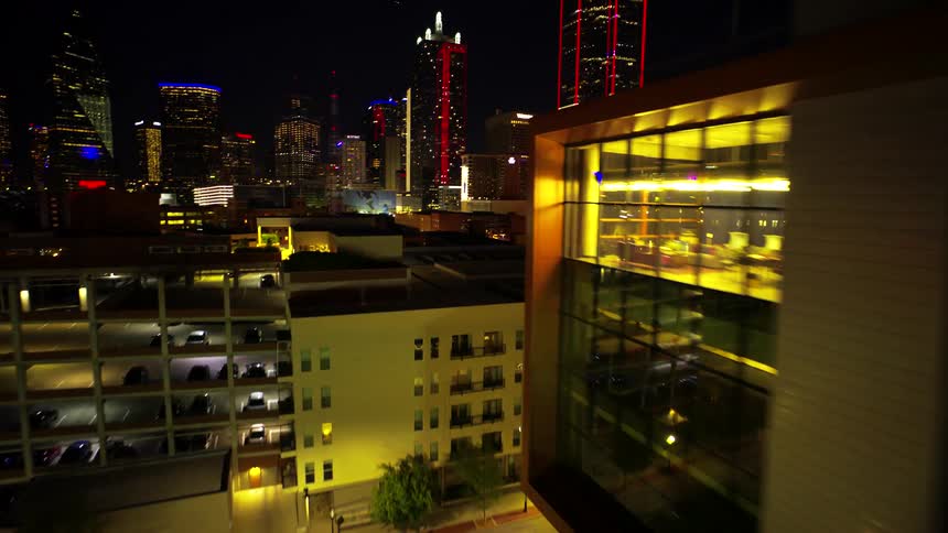 Aerial of a metropolis with brightly lit skyscrapers at night