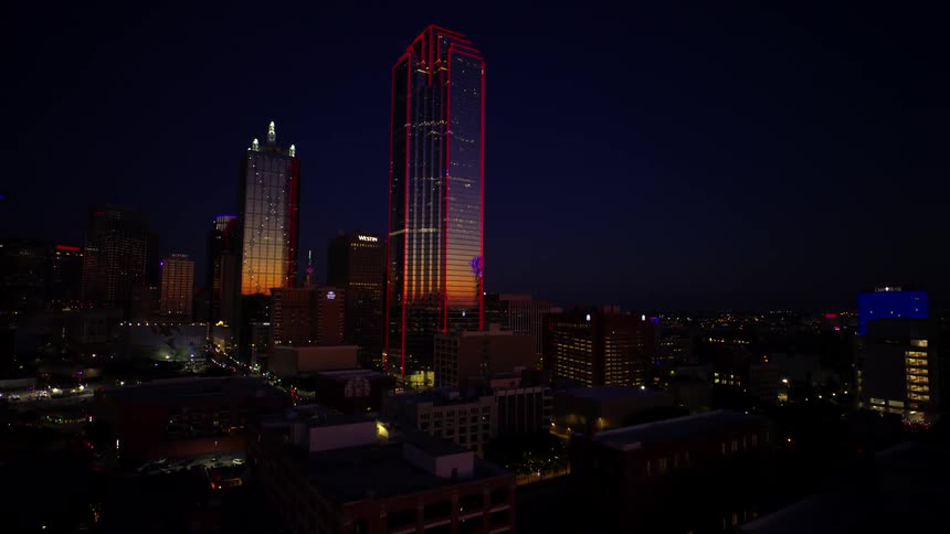 Aerial panorama of a skyscraper with red edges in the center of a metropolis at night