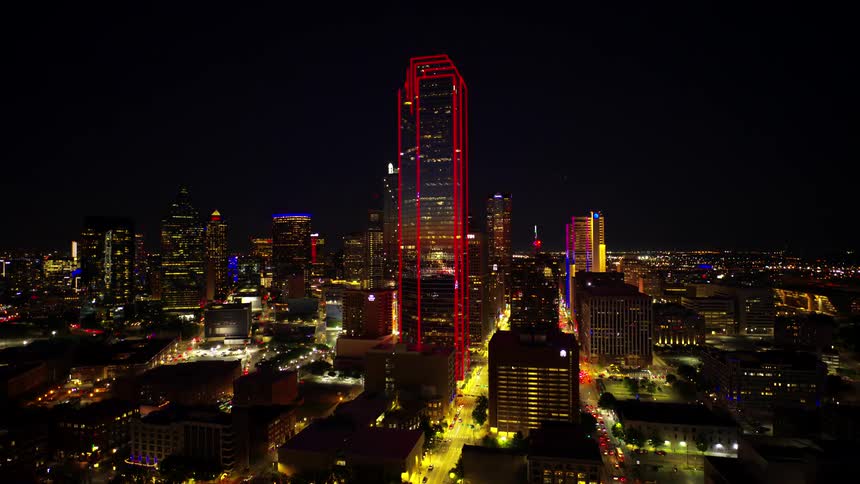 Aerial view of a metropolis with modern skyscrapers illuminated at night