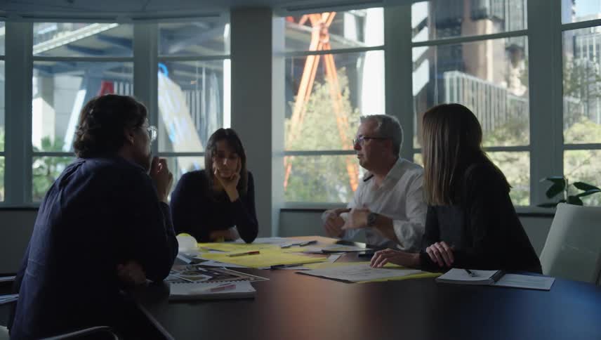 Group of five people in an office meeting talking