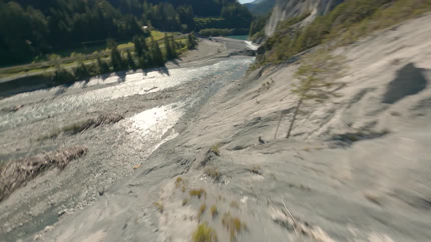 Aerial view of a natural landscape of rocky mountains with a river in Switzerland