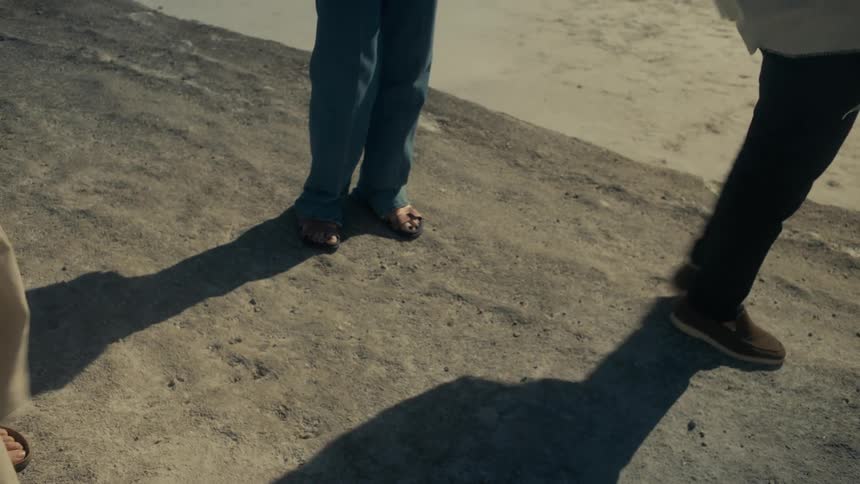 Legs of people walking in a sand