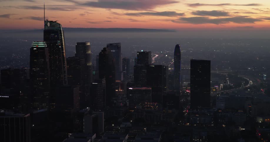 Horizon from a town at dusk with enlightened skyscrapers and an orange sky in the background