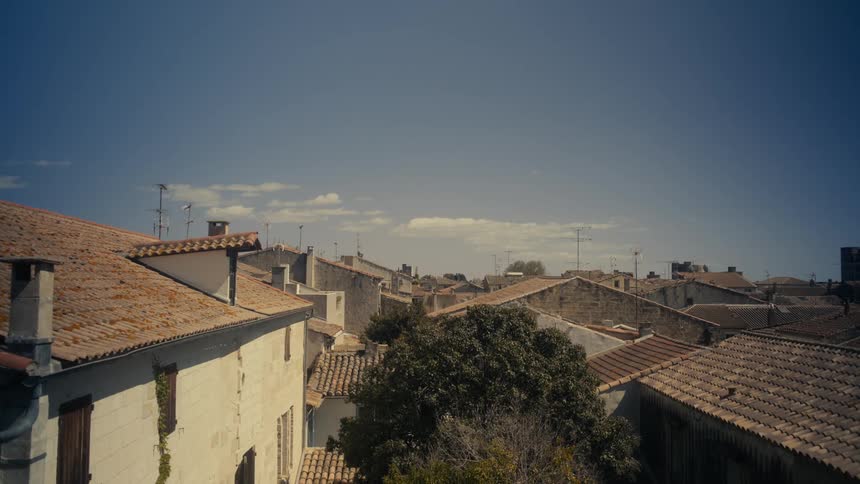 A picturesque view of a small town with terracottatiled roofs under a clear blue sky