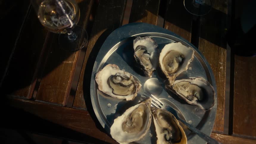 Wooden table with a plate served with fresh mussels