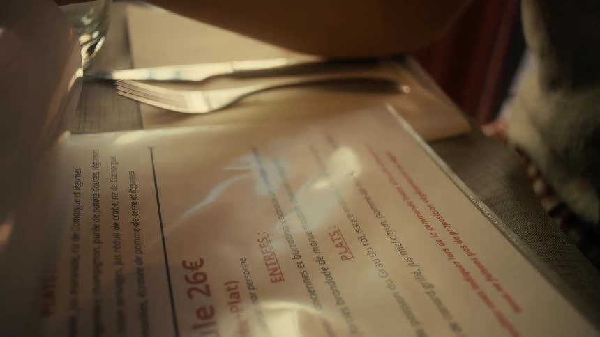 Hands of a person interacting with a menu in a restaurant