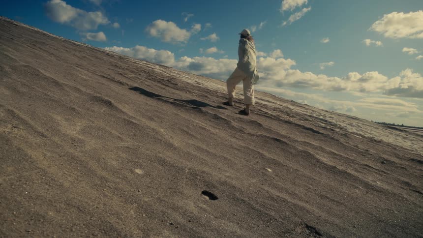 Woman walking up a sand hill