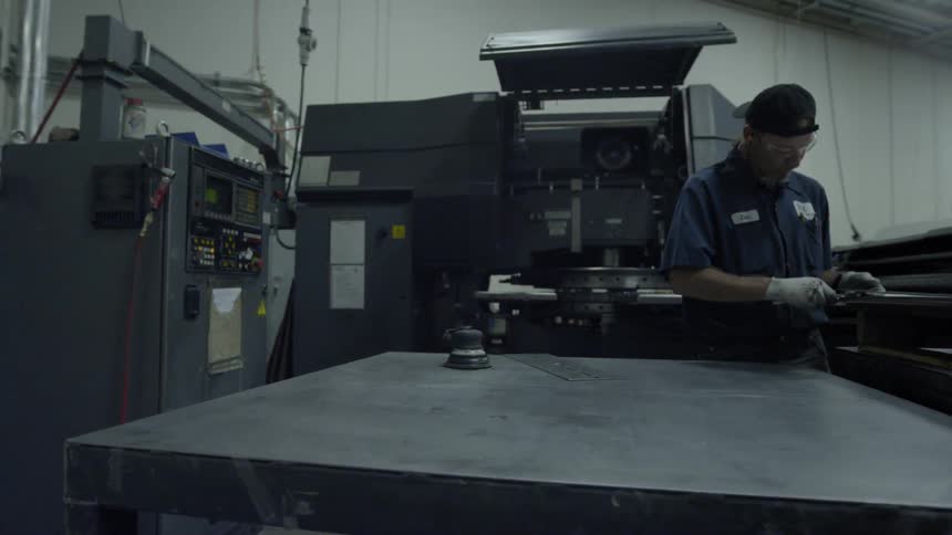 A man is working alongside heavy machinery