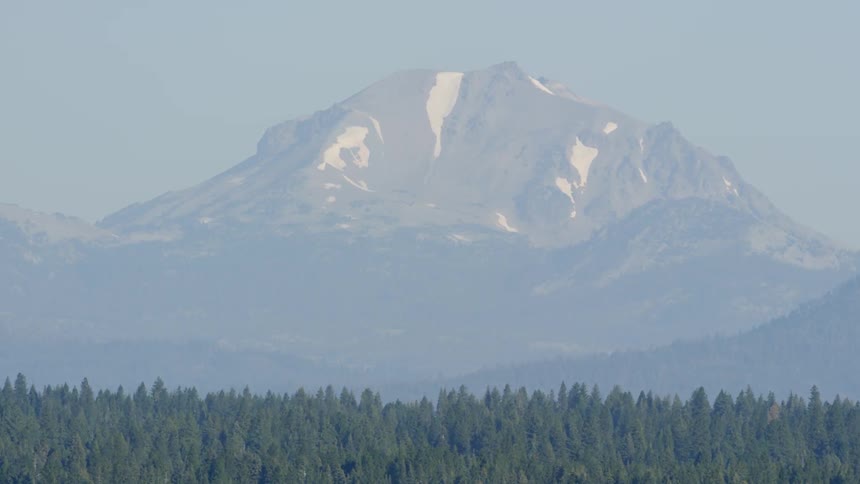 Large mountain sitting beyond a huge forest