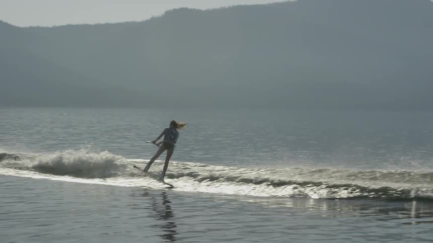 Person water skiing being pulled by a small speed boat