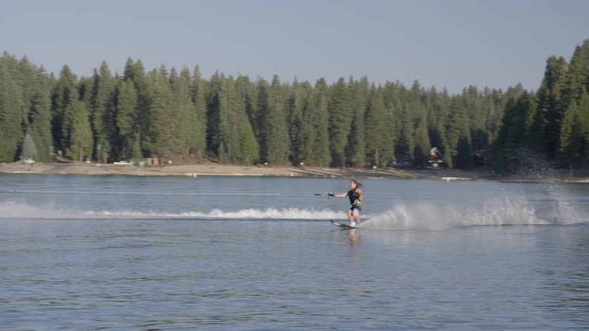 Boat pulling a water skier on a lake on a clear day