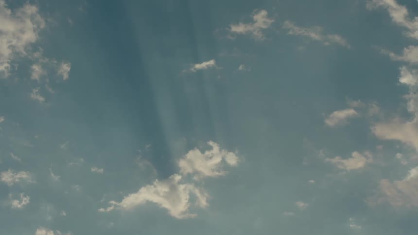 Blue sky with sun rays and clouds