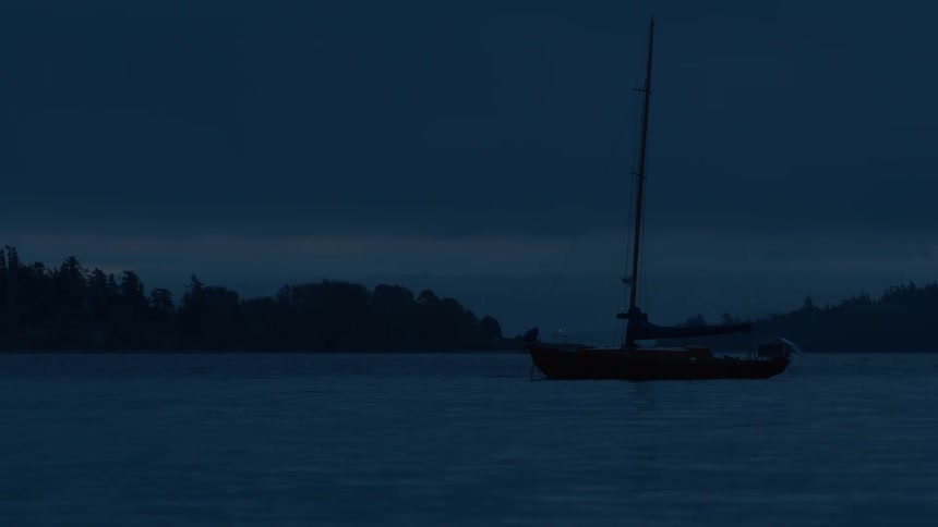 A boat with a huge wooden sail and it is stopped on a lake in a dusk