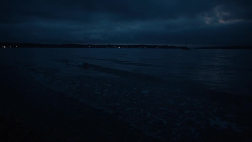 Night landscape of a body of water with a dark cloudy sky