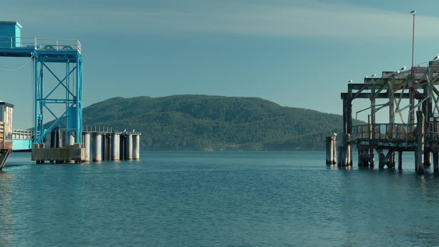 Two piers extend into the water with a hilly landscape in the background