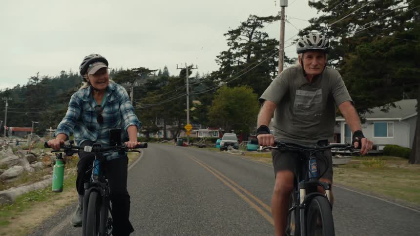 Elderly couple with protective helmet riding a bicycle