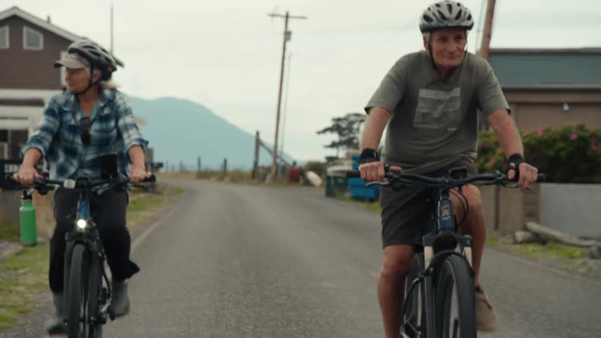 A man and women are riding bikes together