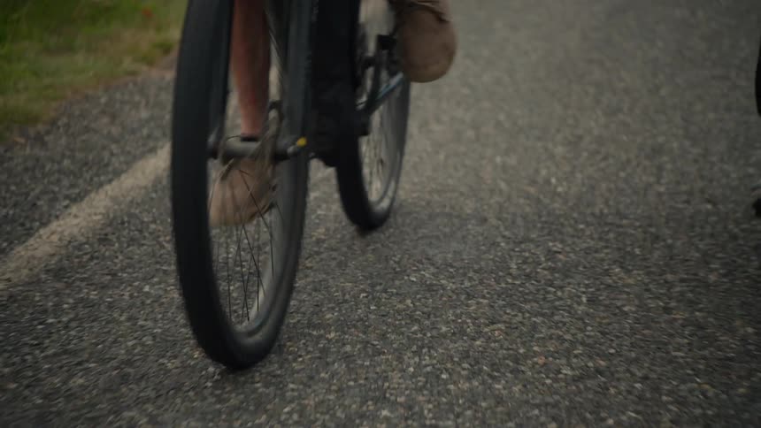 Legs of a person riding a bicycle