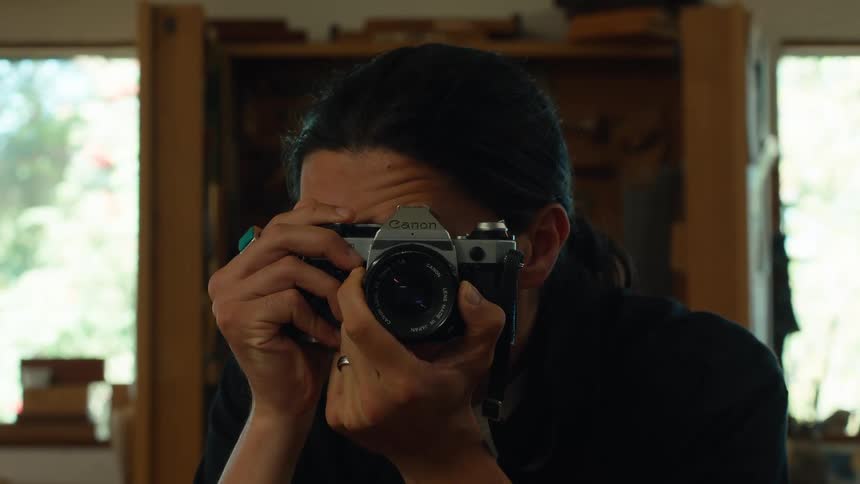 A man holds a camera up to his face ready to take a picture