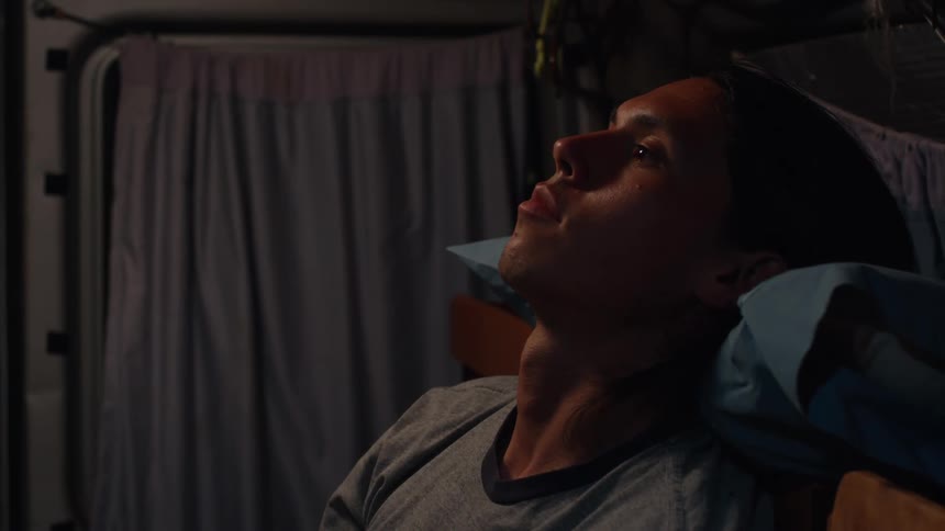 Side portrait of an awake man lying down