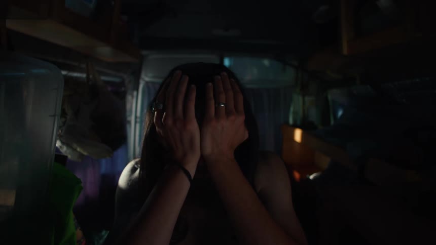 Man waking up and fixing his hair while sitting in a minivan at night