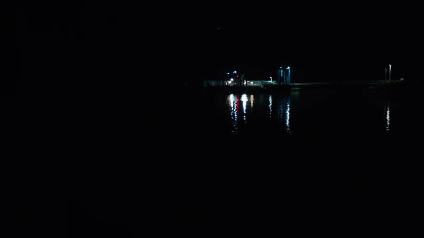 Night view of a lake and in the background a house with lampposts