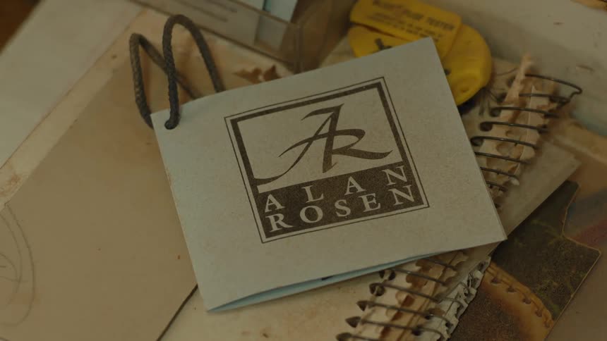 A booklet sits on top of an old notebook on a table