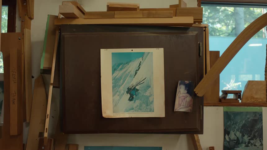 A picture in a wooden frame of a person climbing an ice mountain