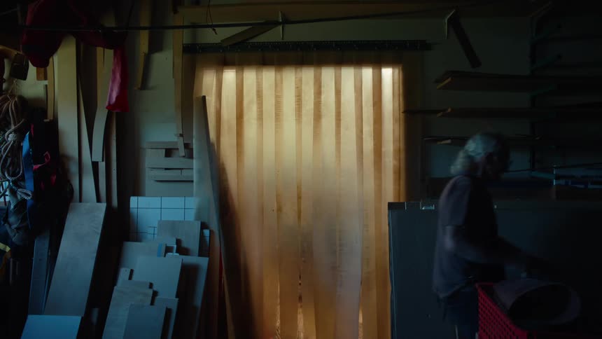 Man walking in an indoor space and passing through a semitransparent curtain