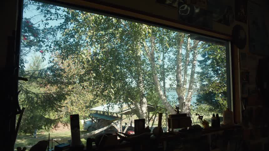 Interior space with carpenters objects with a window overlooking trees on a lake in the background