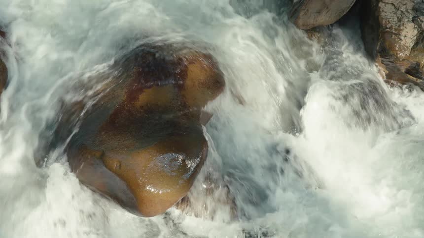 Water of a river flowing between stones