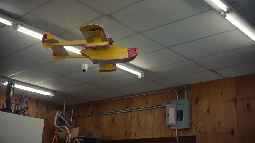 Yellow and red wooden airplane hanging from the ceiling