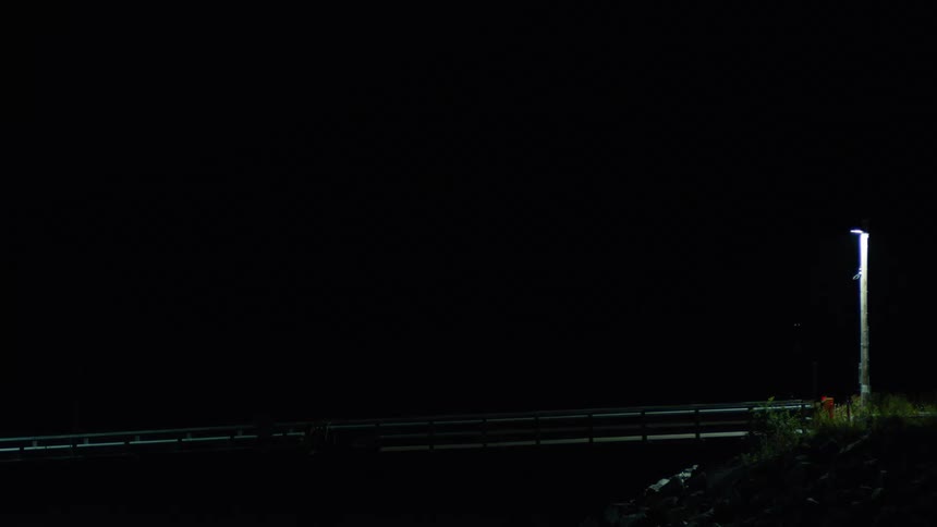The bridge is covered in darkness with only one lamp post