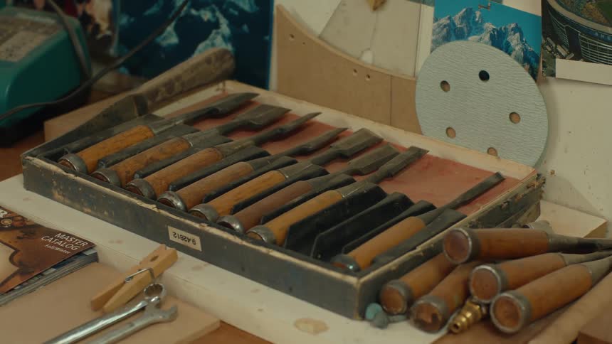 A set of hand tools used to work with wood sitting on a table in a workshop