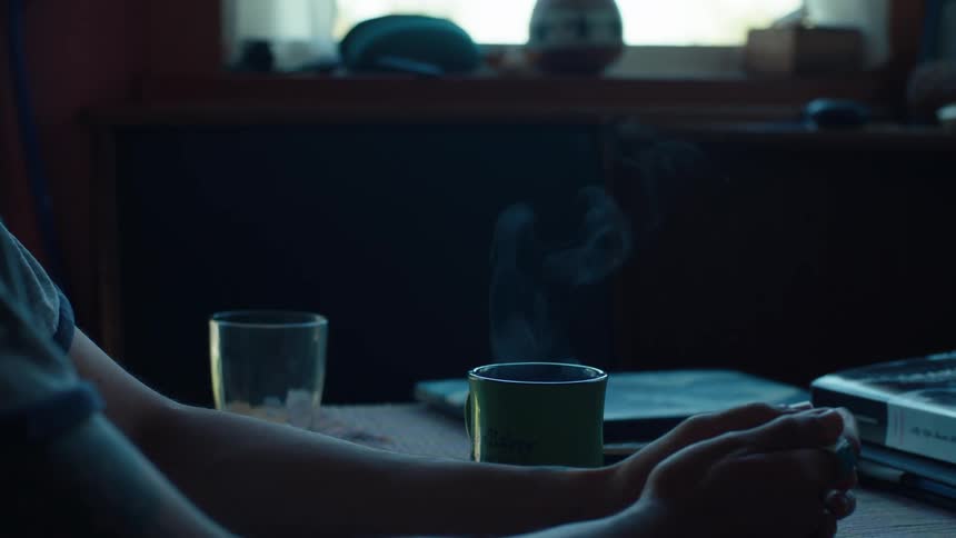 Persons hand closing a book and leaving it on the table