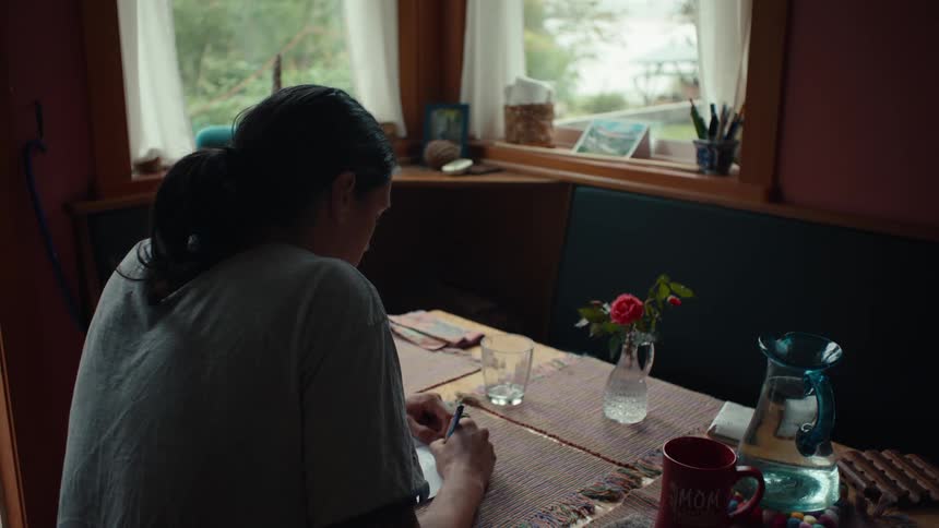 A clip of a male writing on a desk