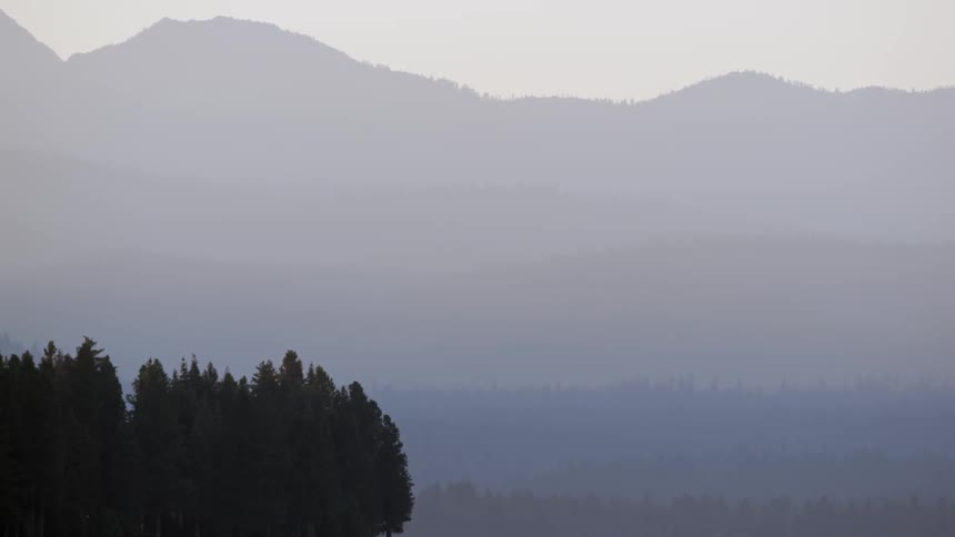 A purple haze hangs over a mountain valley