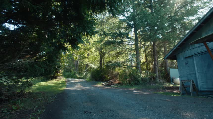 Wooden ranch next to a trail surrounded by trees