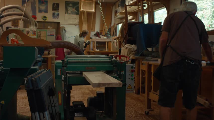 Carpenter placing wooden parts in a machine