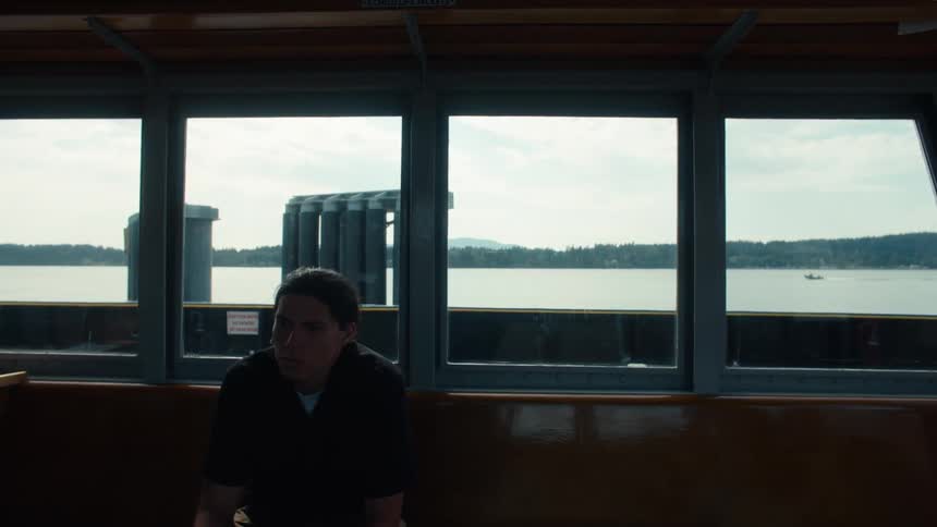 Man sitting on a bench of a ferry boat