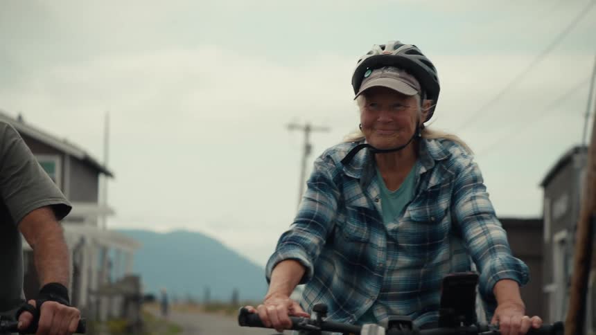 A couple are bike riding and talking