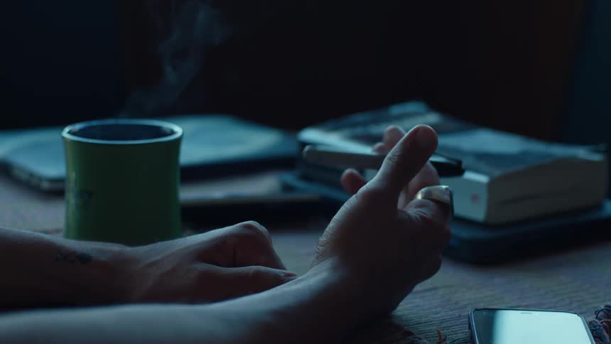 Hand handling a pen on the table